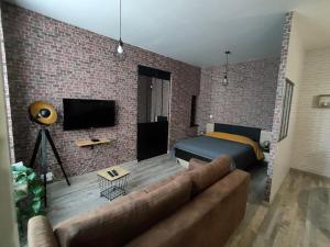 a living room with a couch and a brick wall at Studio Centre Ville Chinon in Chinon