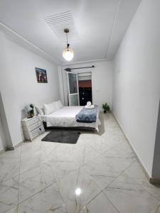 a bedroom with a bed in a white room at FamilyConfort Saidia in Saïdia