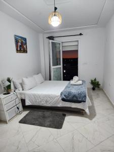 a white bedroom with a large bed and a window at FamilyConfort Saidia in Saïdia