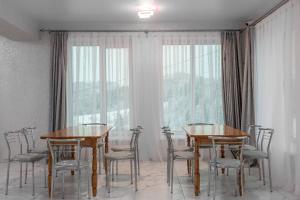 jadalnia z 2 stołami i krzesłami oraz oknem w obiekcie Шепіт Лісу w mieście Bukowel