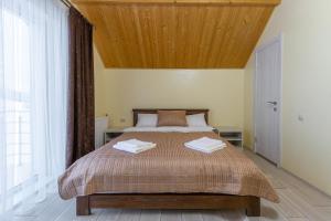 1 dormitorio con 1 cama grande y techo de madera en Шепіт Лісу, en Bukovel
