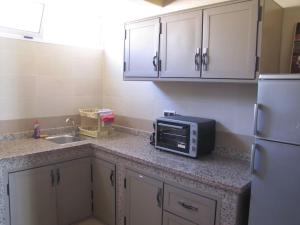 un bancone della cucina con forno a microonde e lavandino di Taghazout Waves 1 a Taghazout