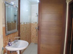 a bathroom with a sink and a wooden door at Taghazout Waves 1 in Taghazout +16 photos