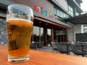 a glass of beer sitting on top of a table at ORION Hotel & Residence Bangna in Bangkok
