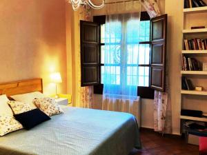 um quarto com uma cama azul e uma janela em Alfapinoalegre em Alfacar