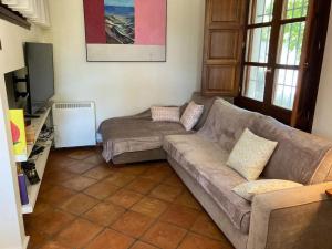 uma sala de estar com um sofá e uma televisão de ecrã plano em Alfapinoalegre em Alfacar