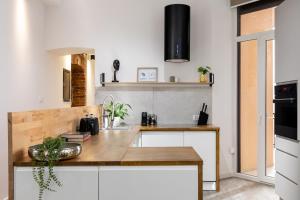 kuchnia z białymi szafkami i drewnianym blatem w obiekcie Luxe Living Castle View w Krakowie +12 zdjęć