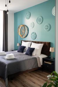 um quarto com uma cama grande e paredes azuis em Luxe Living Castle View em Cracóvia