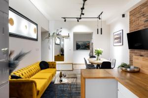 salon z żółtą kanapą i stołem w obiekcie Luxe Living Castle View w Krakowie