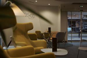 a waiting room with yellow chairs and a table at Seeko'o Hotel Bordeaux in Bordeaux