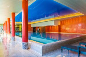a lobby with red columns and a pool at Apartment Alpenrose 2.5 mit Mitbenutzung SPA & Wellness - GRIWA RENT AG in Beatenberg