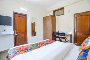 ガーズィヤーバードにあるFabHotel Hexa Ghaziabadのベッドルーム1室(カラフルな毛布付きのベッド1台付)