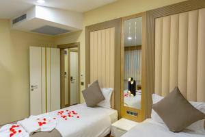 - une chambre avec 2 lits et un miroir dans l'établissement BRAKO HOTEL, à Istanbul