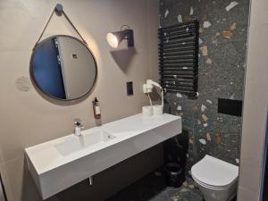 łazienka z umywalką, lustrem i toaletą w obiekcie Biala Perla Sunny Mountain 602 w mieście Sienna