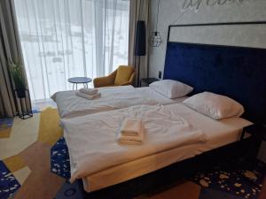 a bedroom with a large bed with two towels on it at Biala Perla Sunny Mountain 602 in Sienna