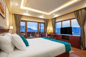 ein Schlafzimmer mit einem großen Bett und einem großen Fenster in der Unterkunft Ashoka Ladakh in Leh
