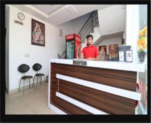 a man standing behind the counter of a restaurant at Ganga Guest House By WB Inn in Agra