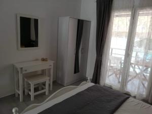 a bedroom with a bed and a desk and a window at Marianna Studios in Aghios Petros Alonissos