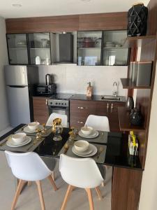 a kitchen with a dining table and white chairs at Aminah’s Space - Jobz Luxury Rental in Bijilo