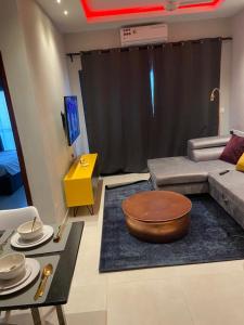 een woonkamer met een bank en een tafel bij Aminah’s Space - Jobz Luxury Rental in Bijilo