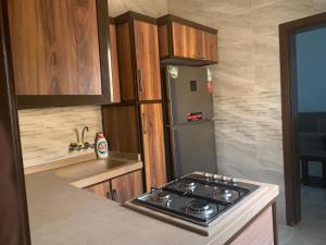 a kitchen with a stove and a refrigerator at فيلا المنزل in Makkah