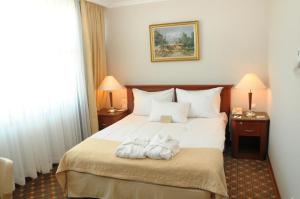 a hotel room with a bed with towels on it at Hotel Midi in Ankara