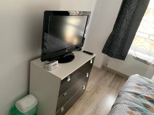 a tv on top of a dresser in a bedroom at B&B Iulius in Cluj-Napoca