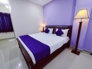 a bedroom with a large bed with purple walls at Hotel Prime Classic in Shamshabad