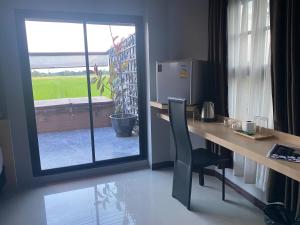 a desk with a chair and a window in a room at Maze Pool Villa Resort in Kamphaeng Phet