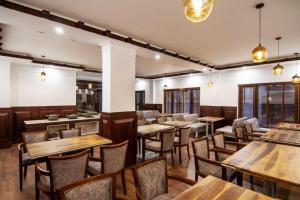 a dining room with wooden tables and chairs at Ashoka Ladakh in Leh +14 photos