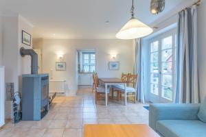 a living room with a table and a fireplace at Rosenhuus in Risum-Lindholm