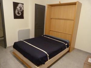 a bedroom with a bed and a wooden door at Appartement T.2 - Parking -Gratuit in Vierzon
