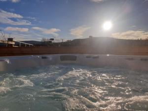 une baignoire remplie d'eau et de soleil en arrière-plan dans l'établissement Charming boutique forest view cabin with hot tub in Ballater, à Ballater