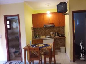 a small kitchen with a table and a television at CHRYSPY Toulatos Studios in Pouláta