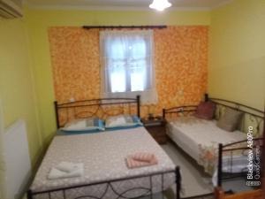 a bedroom with two beds and a window at CHRYSPY Toulatos Studios in Pouláta
