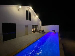 a house with a swimming pool at night at Maze Pool Villa Resort in Kamphaeng Phet