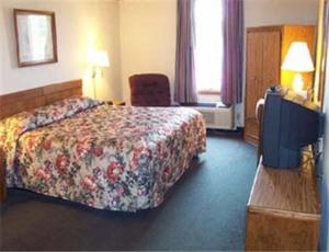 a hotel room with a bed and a television at State Line Inn in Hagerstown