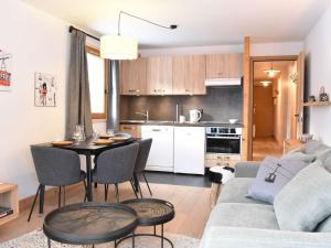 a kitchen and living room with a table and a couch at Charmant T3 avec balcon, ascenseur et piscine en été, proche pistes et centre, idéal pour 6 pers. - FR-1-180-565 in Les Allues