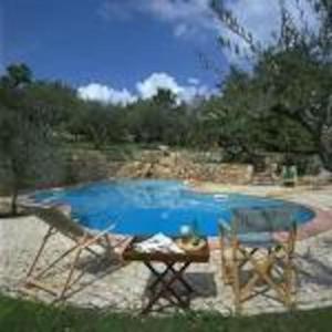 Pontelandolfo的住宿－La Locanda Della Presuntuosa，一个带两把椅子和一张桌子的蓝色小游泳池