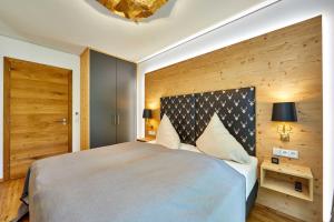 a bedroom with a large bed and a wooden wall at Parkresidenz in Garmisch-Partenkirchen