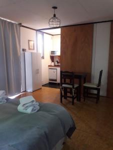 ein Schlafzimmer mit einem Bett und einem Tisch sowie eine Küche in der Unterkunft vagones de la patagonia in El Calafate