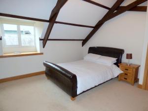 a bedroom with a black leather bed and a window at Great Barns in South Pool