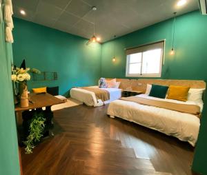 恆春的住宿－麋宿Mi House墾丁包棟，一间设有两张床和绿色墙壁的客房
