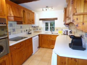 a kitchen with wooden cabinets and white appliances at Great Barns in South Pool