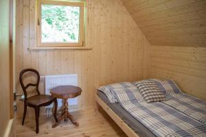 1 dormitorio con 1 cama, 1 mesa y 1 silla en BIJAKÓWKA en Ustrzyki Dolne
