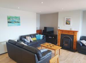 a living room with two couches and a fireplace at Ballycotton Holiday Apartment No 6 by Trident Holiday Homes in Ballycotton