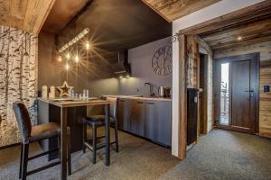 a kitchen with a table and chairs in a room at Appartement Ô Bouleau in La Tzoumaz