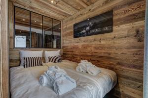 a bedroom with two beds in a wooden wall at Appartement Ô Bouleau in La Tzoumaz