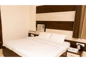 - une chambre dotée d'un lit avec des draps blancs dans l'établissement Ritumbhara Hotel & Resort, à Alwar