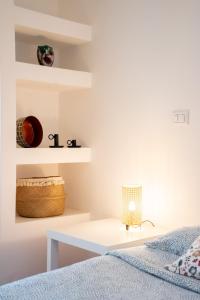 a white bedroom with a bed and a desk at Casa d’autore siciliana in Milan